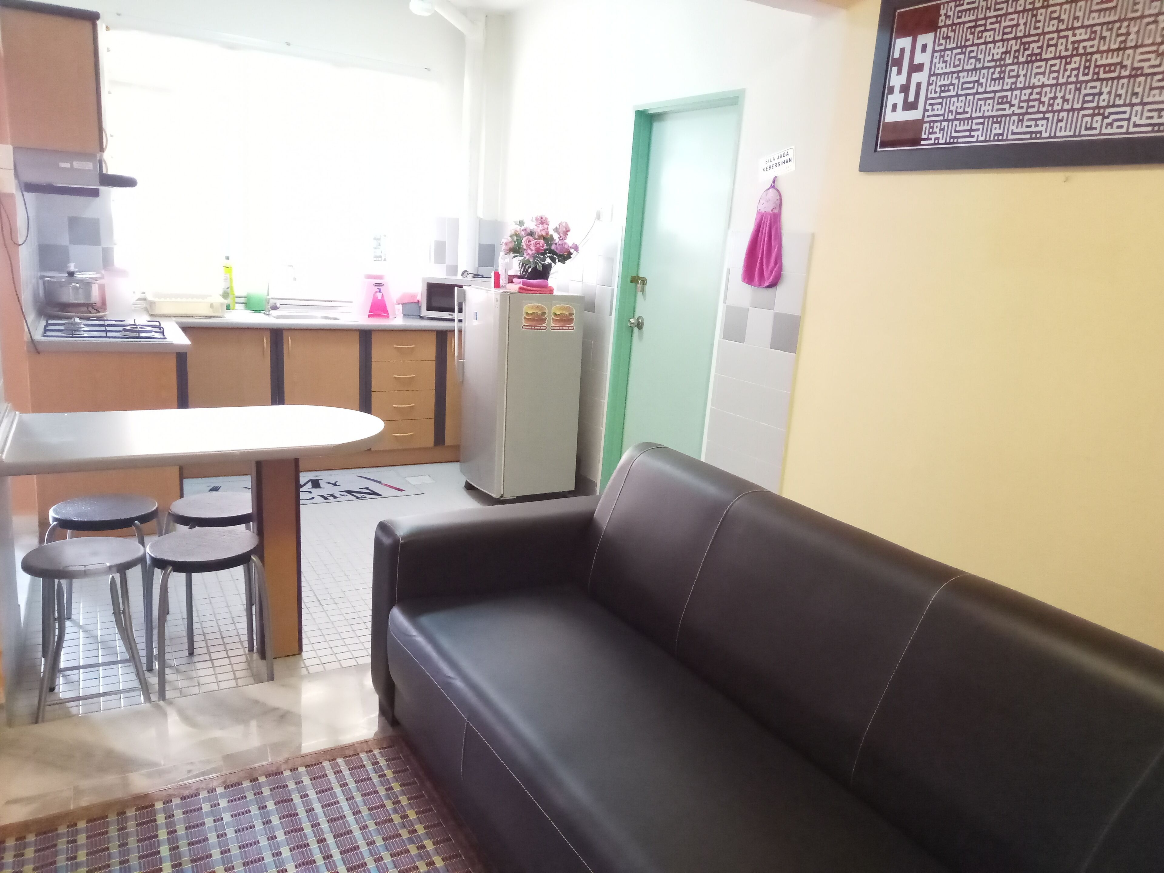 A compact living space with a kitchenette, a dining area with a table and chairs, and a sofa.