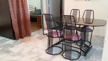 Uma årea de refeiçÔes com uma mesa e quatro cadeiras.