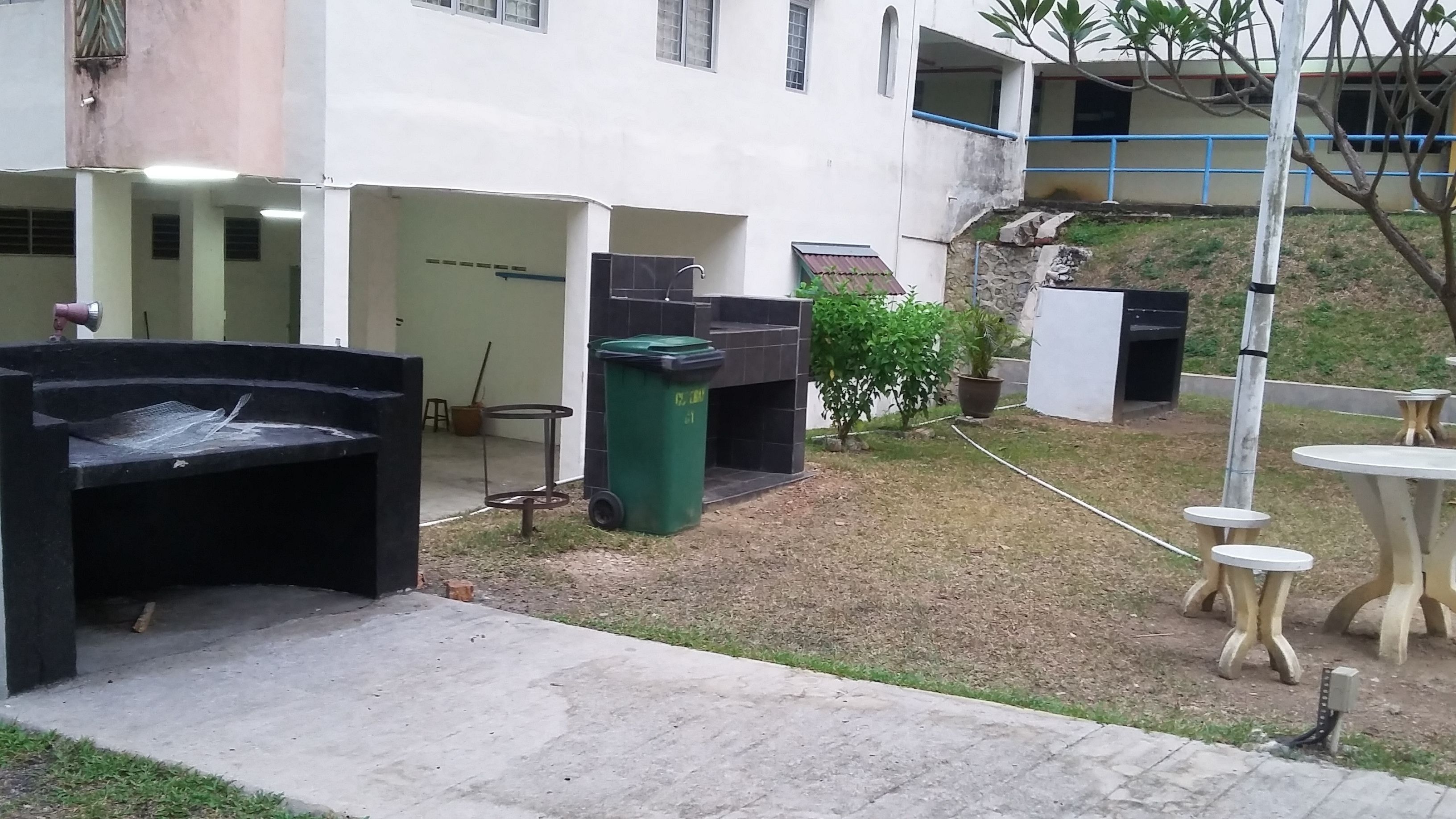 A courtyard with outdoor seating, a trash bin, and a water fountain.