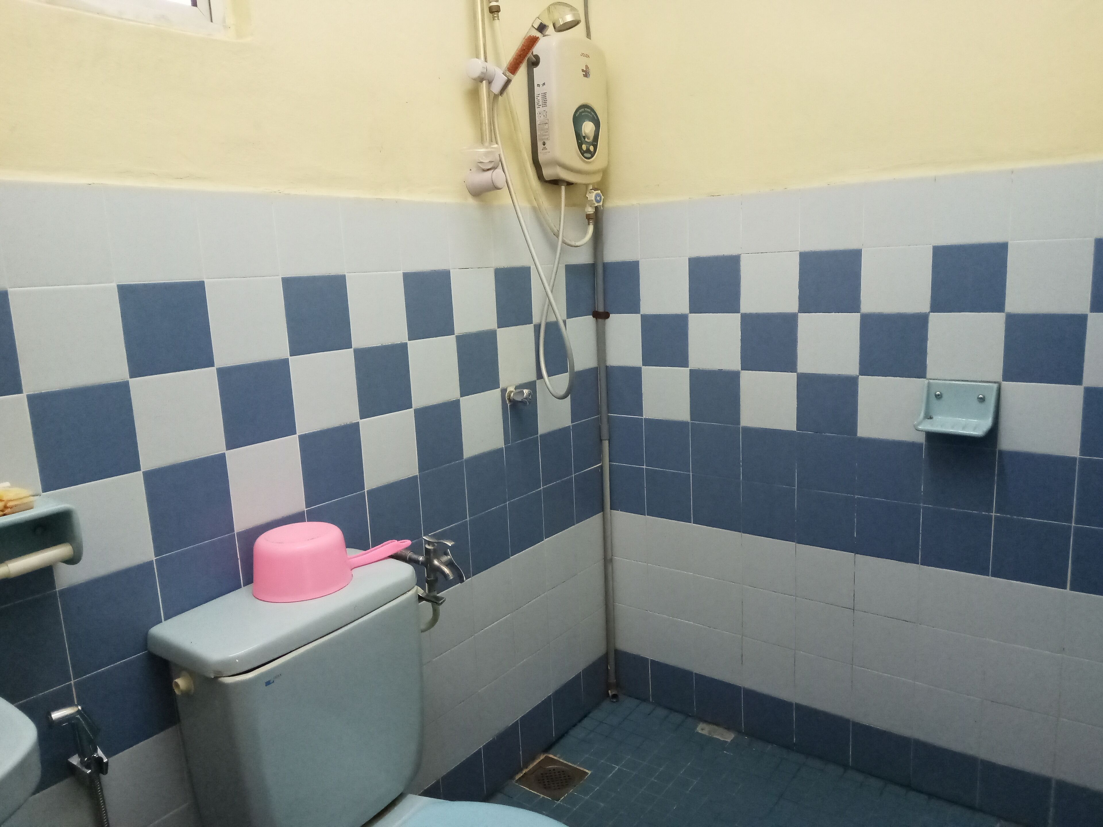 A small bathroom with a toilet, a shower, and a sink.