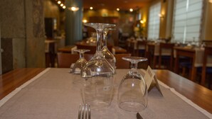 A table set with wine glasses, a fork, and a knife, indicating a dining area in a restaurant. - Hotel Yerri (Estella)