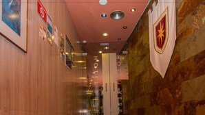 A hotel corridor with wooden walls, a marble floor, and a red ceiling. - Hotel Yerri (Estella)