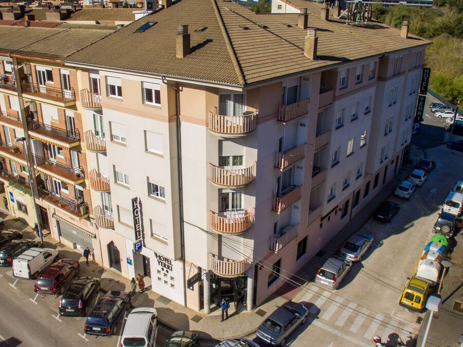 A multi-story hotel with balconies, a bar, and a parking lot.