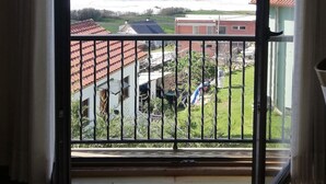 Ein Balkon mit Blick auf das Meer und ein Wohngebiet.
