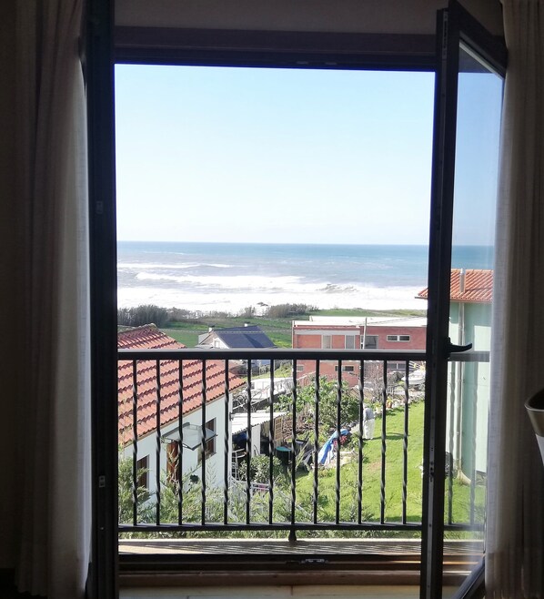 A balcony with a view of the sea and a residential area. - Hotel A Raíña (Oia)