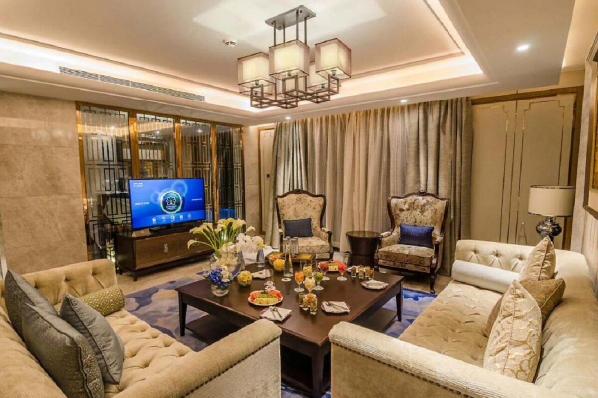 Un salón espacioso con un televisor de pantalla plana grande, asientos cómodos y un adorno decorativo.
