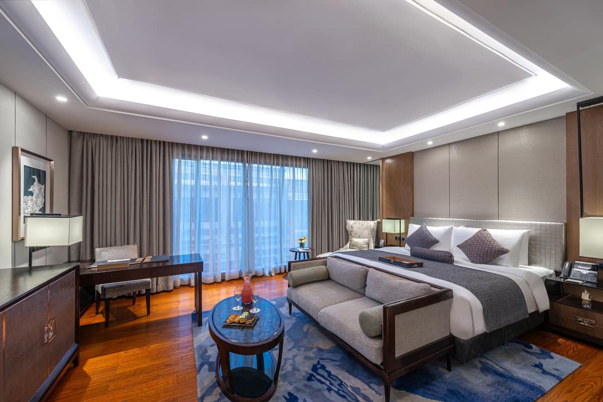 Une chambre d’hôtel moderne équipée d’un grand lit, d’un canapé, d’un bureau et d’une table à manger.