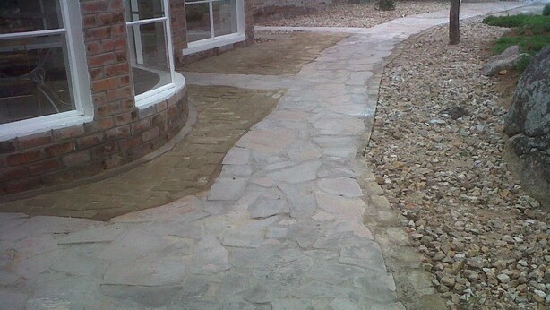 A stone pathway leading to a building with large windows and a brick exterior. - Nora Valley Lodge (Harare)