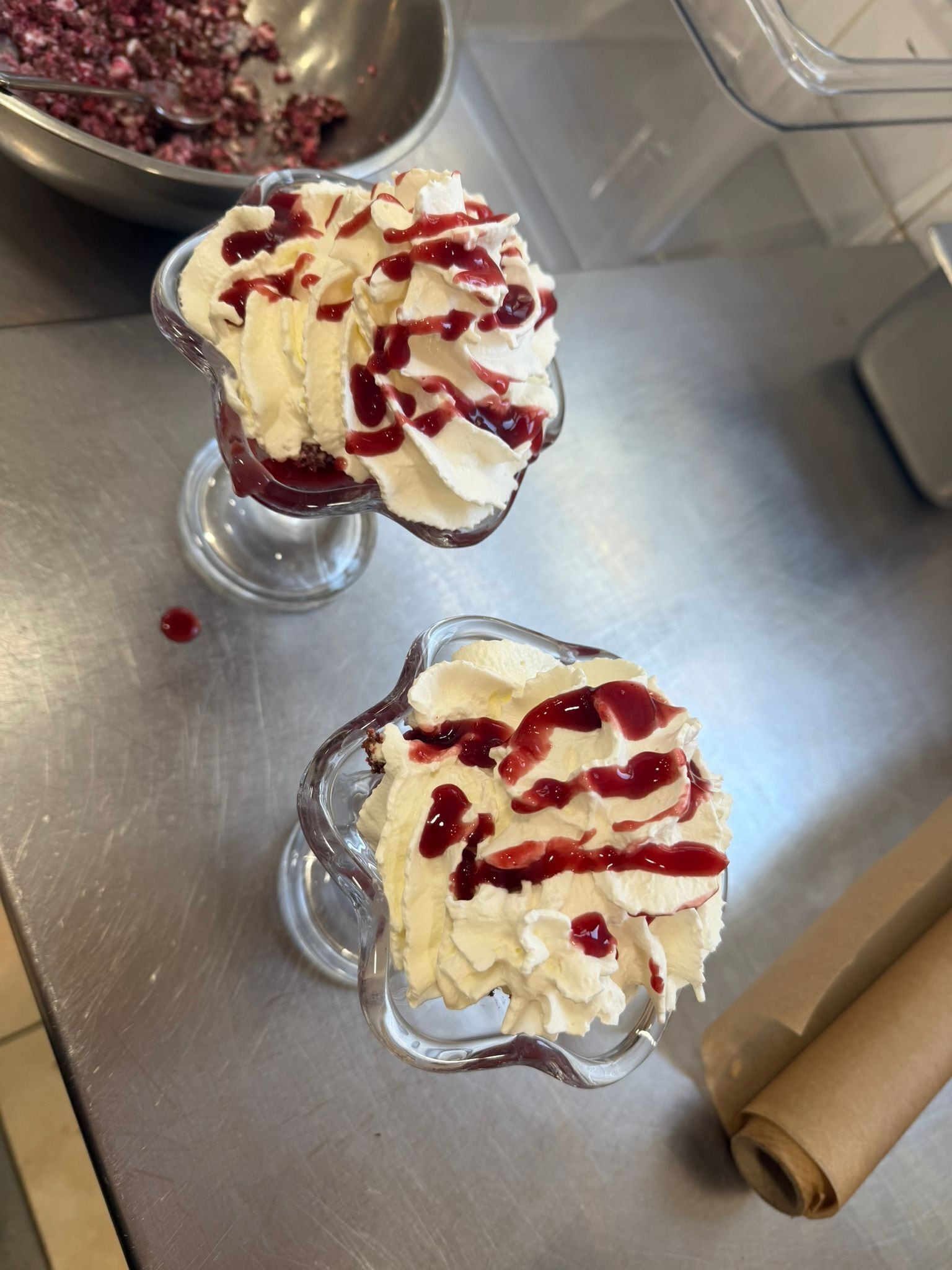 Two dessert glasses on a metallic surface.