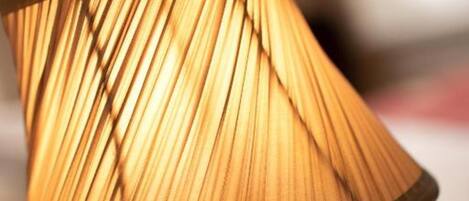 A close-up of a lamp with a pleated shade.