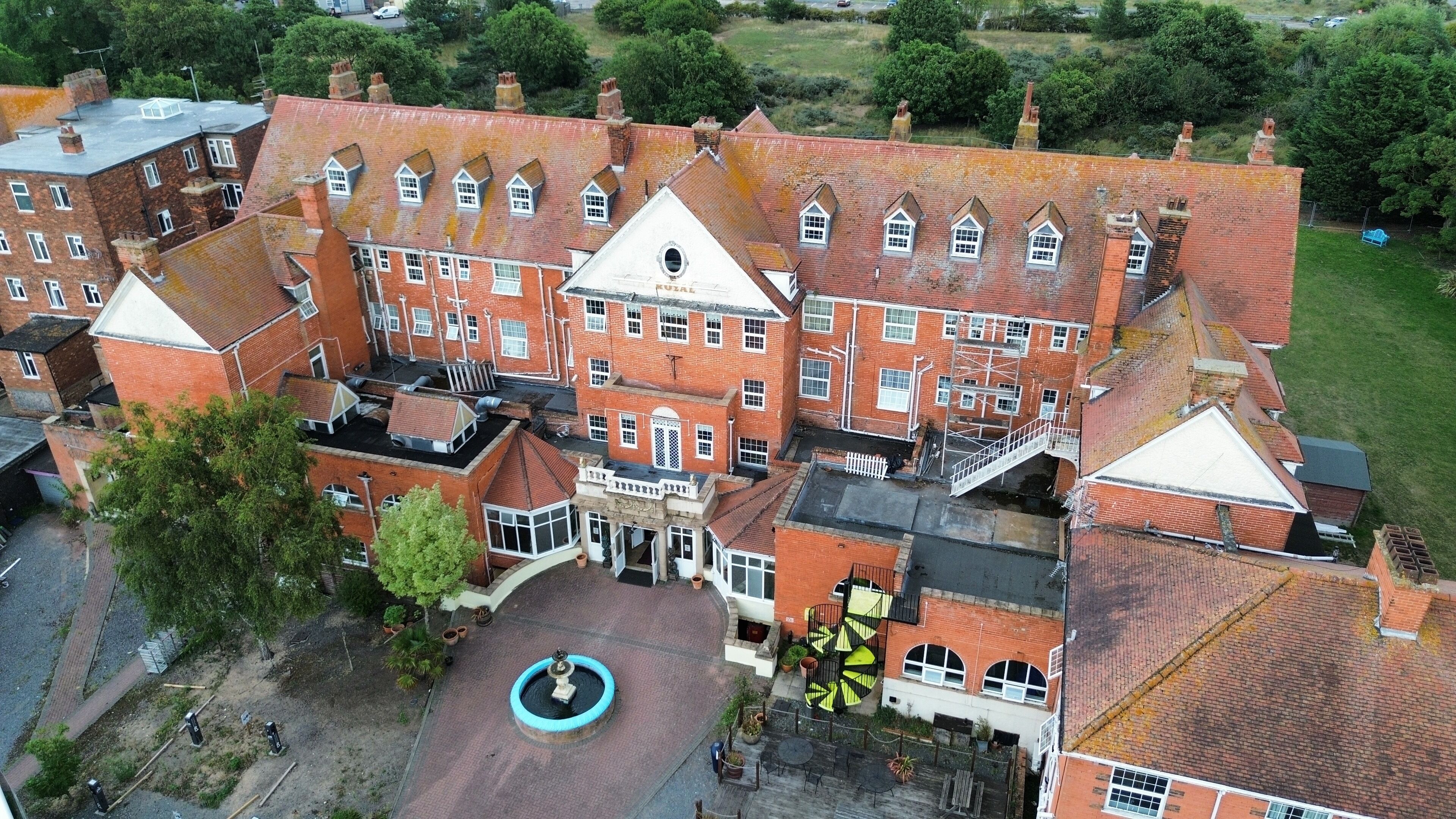 A large, historic building with multiple wings and a central courtyard.