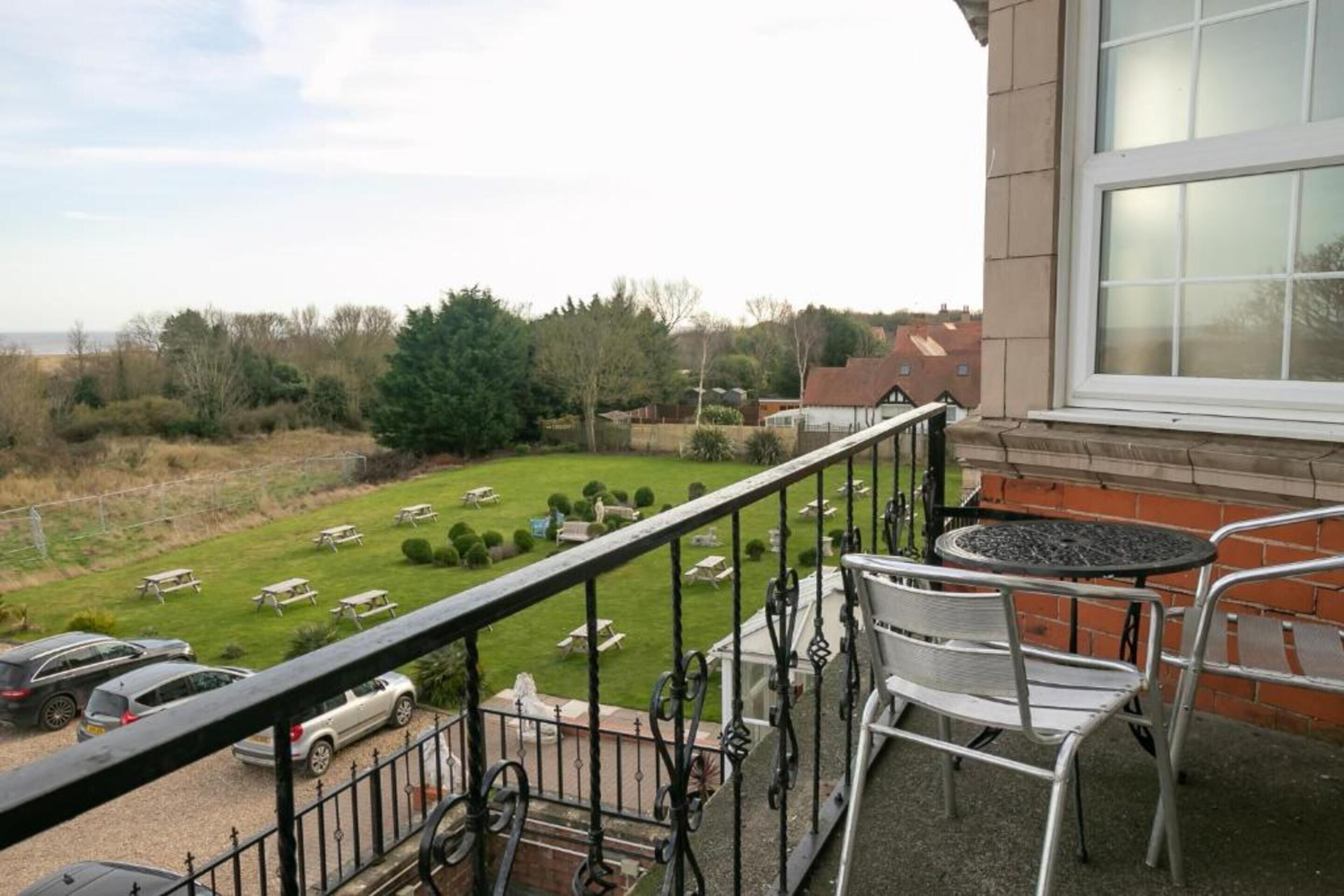 En balkon med udsigt over en kirkegård, en murstensmur og et vindue.