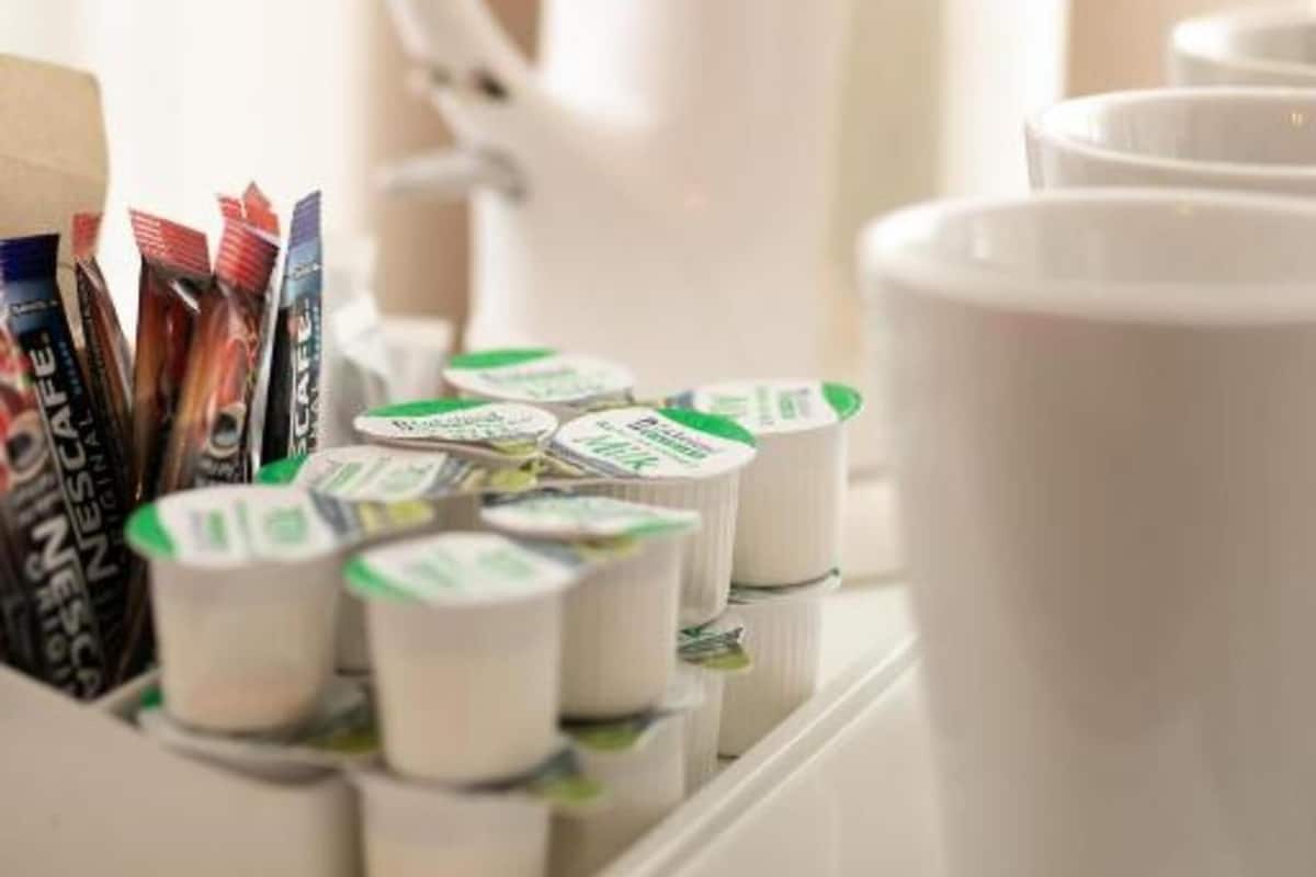 Un plateau avec des dosettes de café et une machine à café blanche.