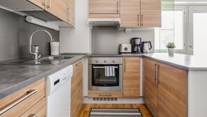 Eine moderne Küche mit Edelstahlgeräten, Holzschränken und einem eingebauten Backofen.