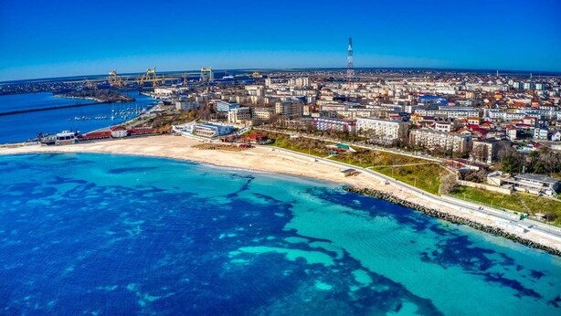 An aerial view of a coastal city with a beach, marina, and industrial area. - Mera Brise (Mangalia)