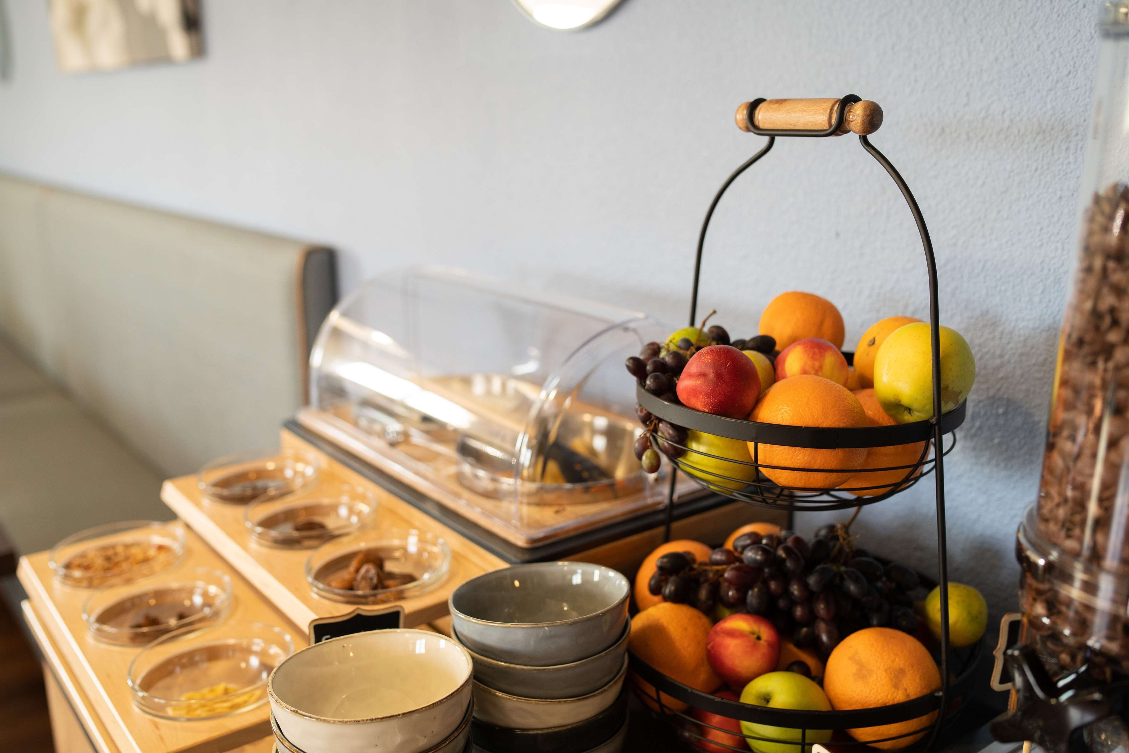 A buffet setup with a fruit display, bowls, and a coffee station.
