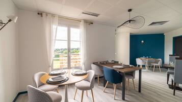 A modern dining area with round tables, chairs, and a view of the outdoors.