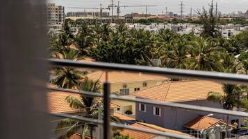 Un quartier résidentiel avec des maisons, des palmiers et, au loin, un chantier de construction.