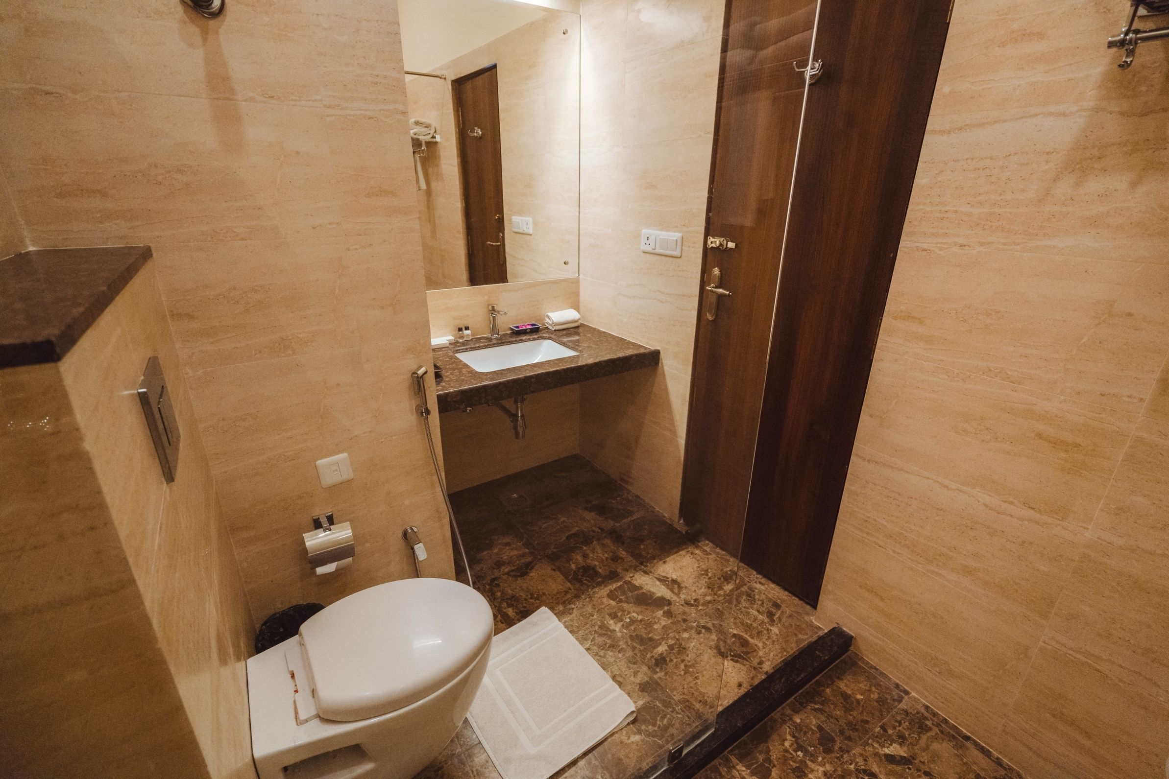 Un bagno compatto con il water, il lavandino e uno specchio.