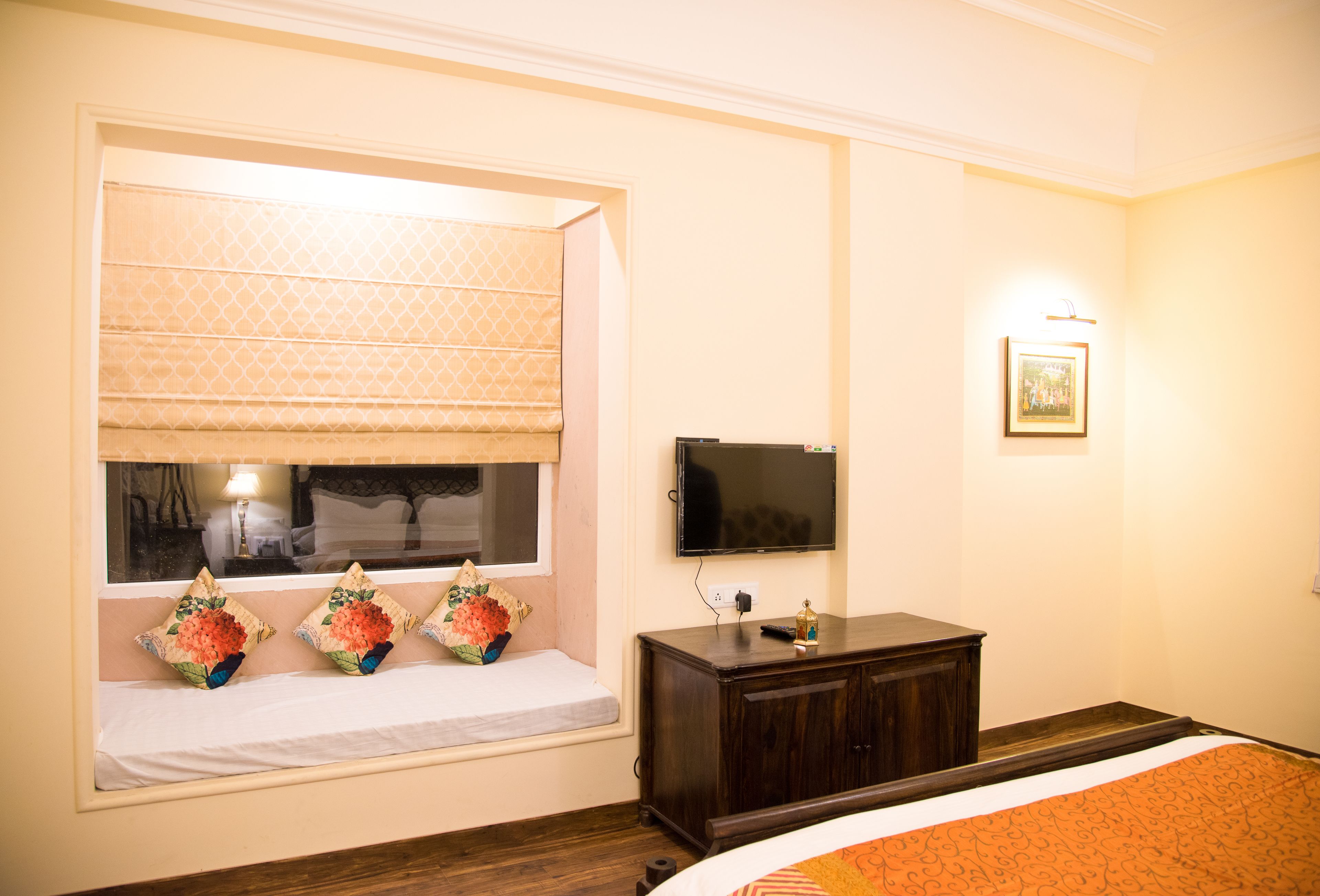 Een hotelkamer met een bed, een raam met uitzicht, een televisie en een klein kastje.