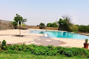 Alberca al aire libre y camastros 