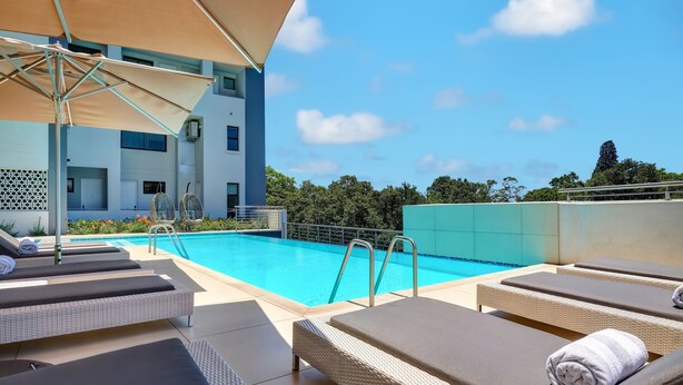 A rooftop pool area with lounge chairs and umbrellas.