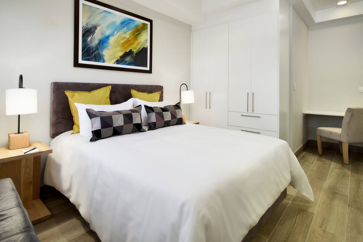 Ein modernes Hotelzimmer mit einem großen Bett, einem Schreibtisch und einem Stuhl.