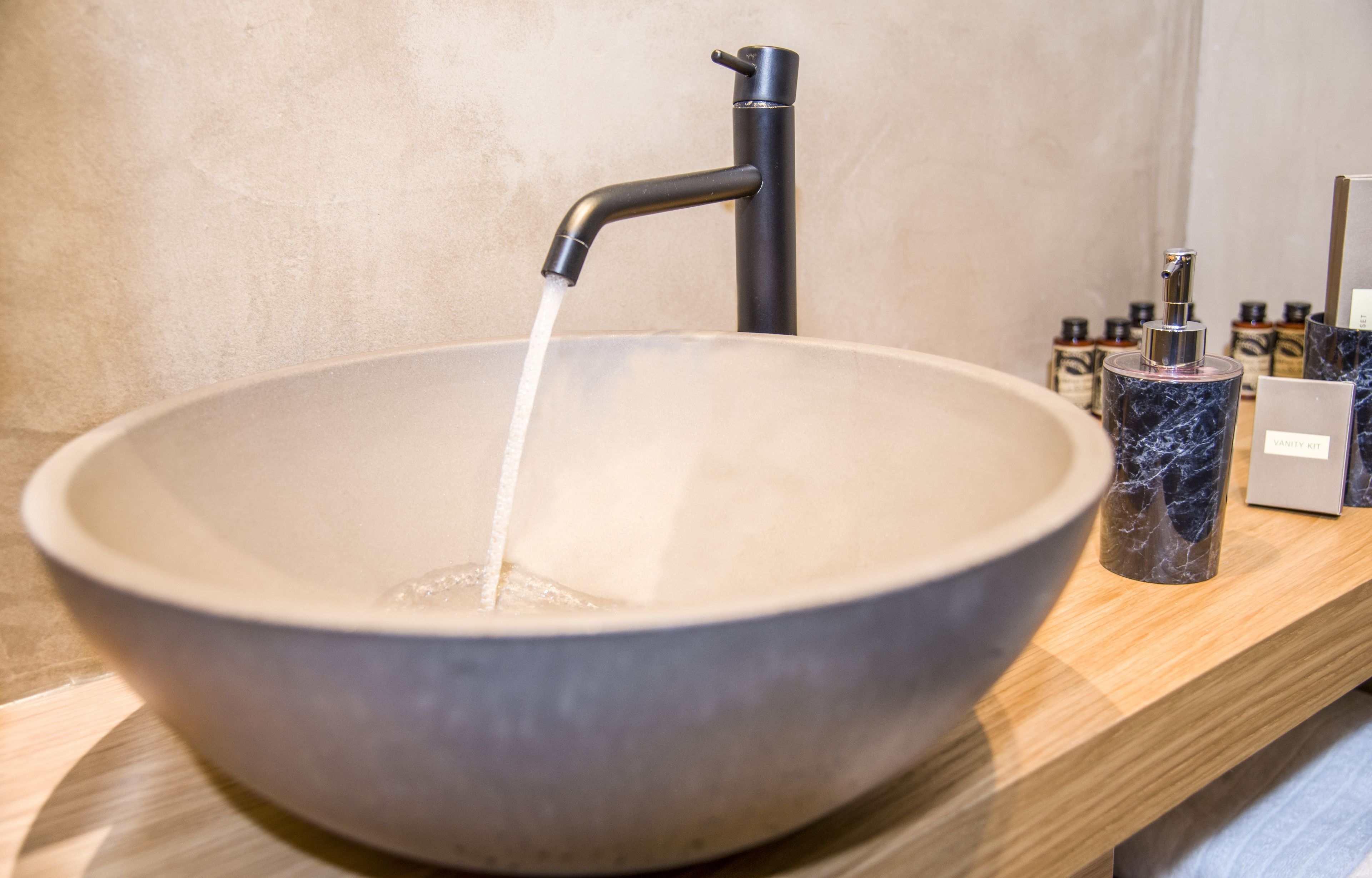 Un lavamanos moderno con un grifo elegante y una lavabo de mármol.