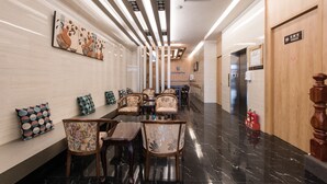 A hotel lobby with a long reception desk, multiple chairs, a wall-mounted artwork, and a polished marble floor. - Kenting Kaiying Hotel (Hengchun)