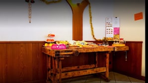 Een houten tafel met diverse etenswaren en een prikbord op de achtergrond.