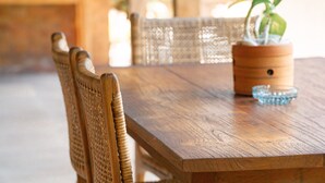 A wooden dining table with a potted plant and a glass bowl.