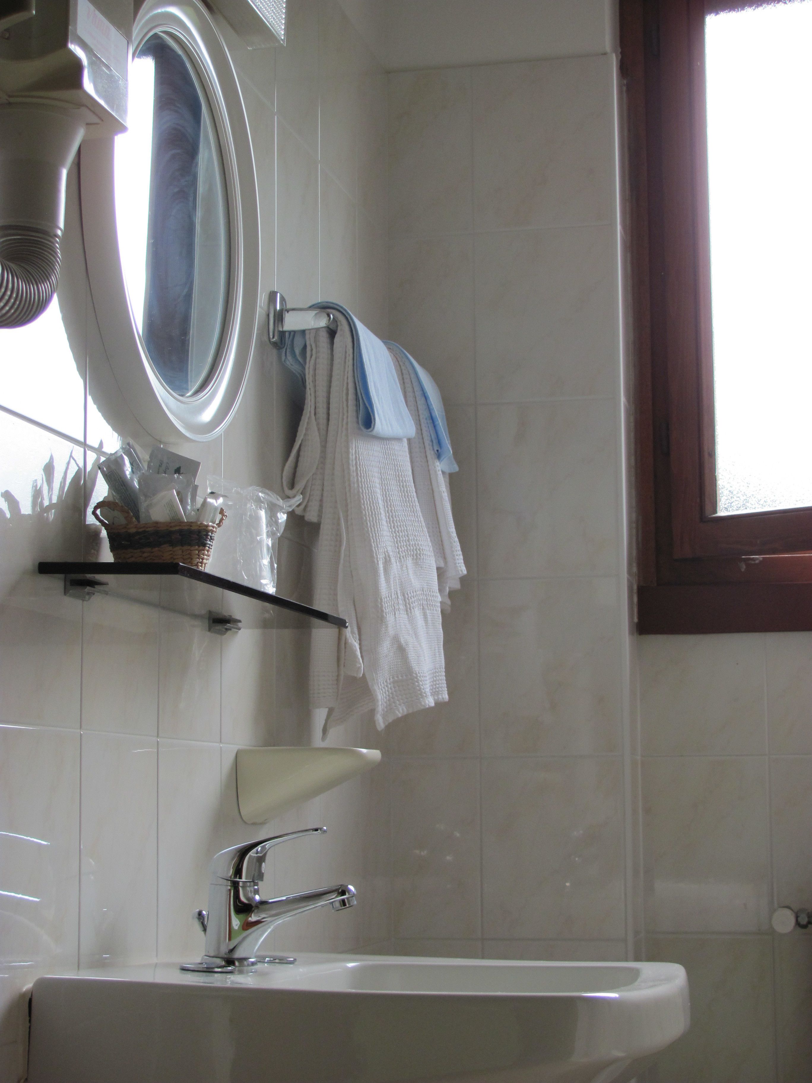 A bathroom with a sink, mirror, and towel rack.