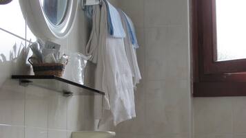 A bathroom with a sink, mirror, and towel rack.