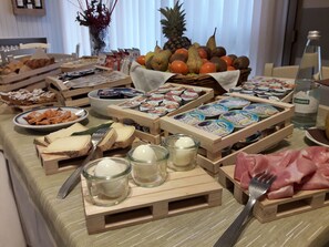 A buffet table with various food items, including fruits, cheeses, and packaged goods. - La Genzianella (Miasino)