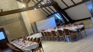 A spacious hall with high ceilings and exposed beams, furnished with wooden tables and chairs, suitable for events or gatherings. - Auberge du jeu darc (Mello)