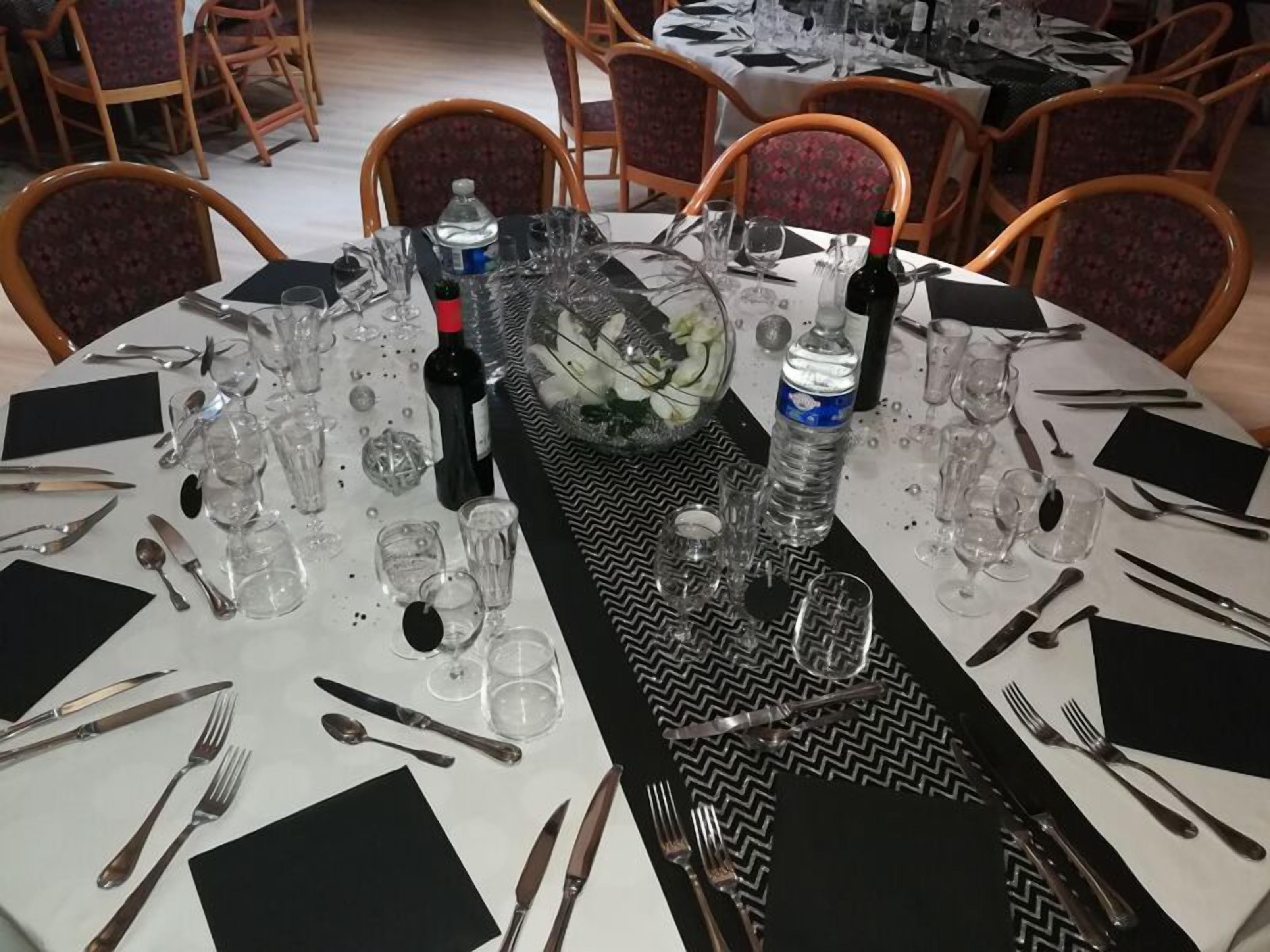 Une table à manger dressée pour un repas, avec plusieurs chaises disposées autour.