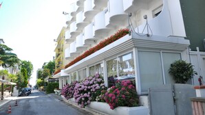 Un hôtel doté de balcons ornés de fleurs et offrant une vue sur la rue.