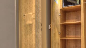 A bathroom with a wooden vanity, a toilet, and a shower area.