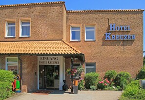 A brick building with a sign reading "Hotel Kreuzer" and "Eingang Hotel Kreuzer" indicating the entrance. - Hotel Kreuzer (Wedel)