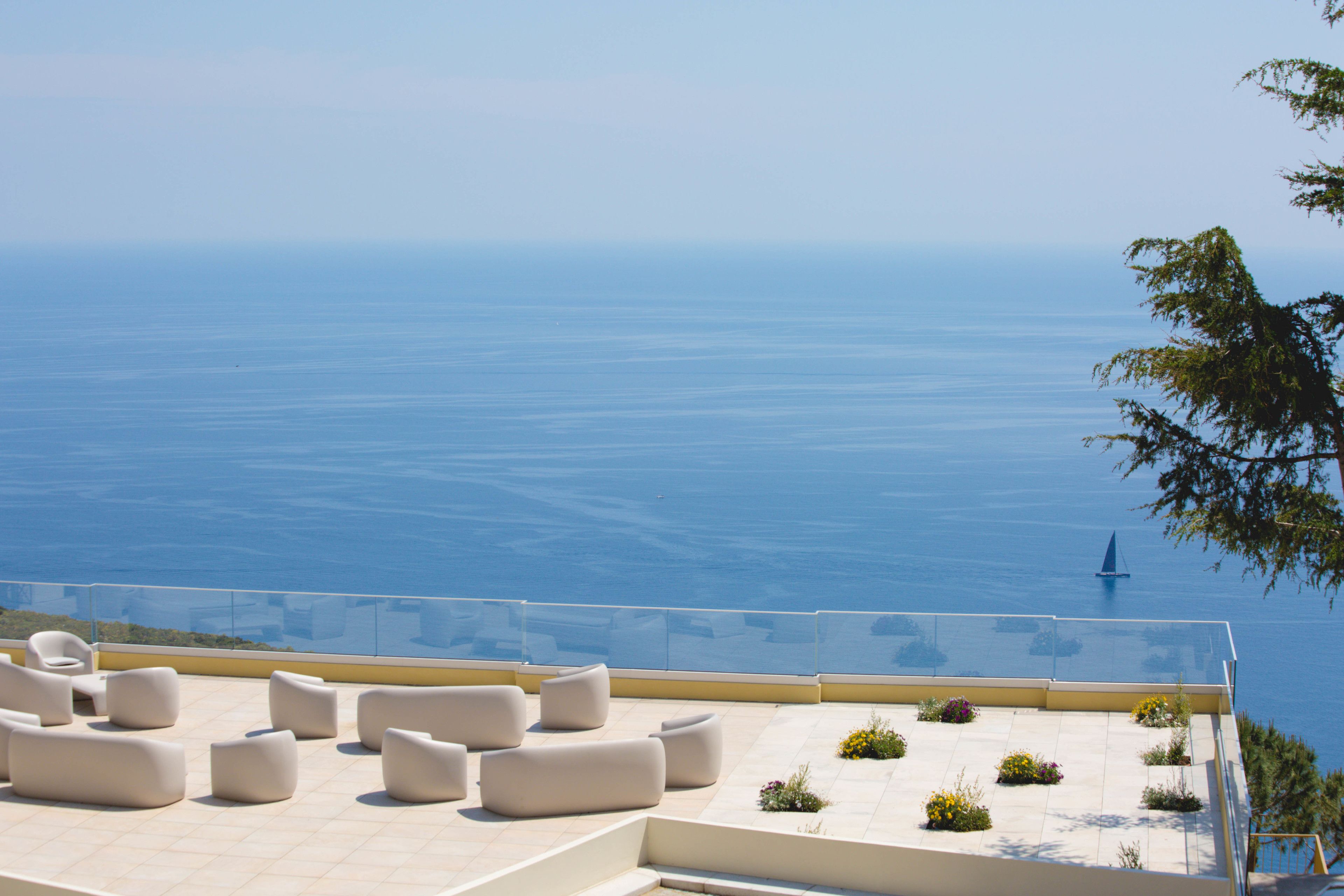 A rooftop terrace with outdoor seating and a view of the sea.