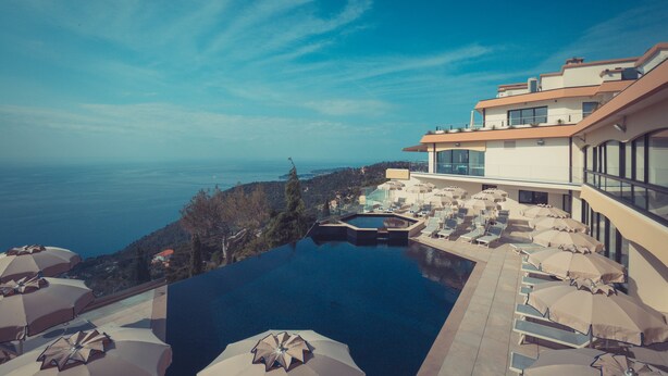 A modern hotel with a rooftop infinity pool overlooking a coastal view. - Hôtel Les Terrasses D'Eze (Èze)