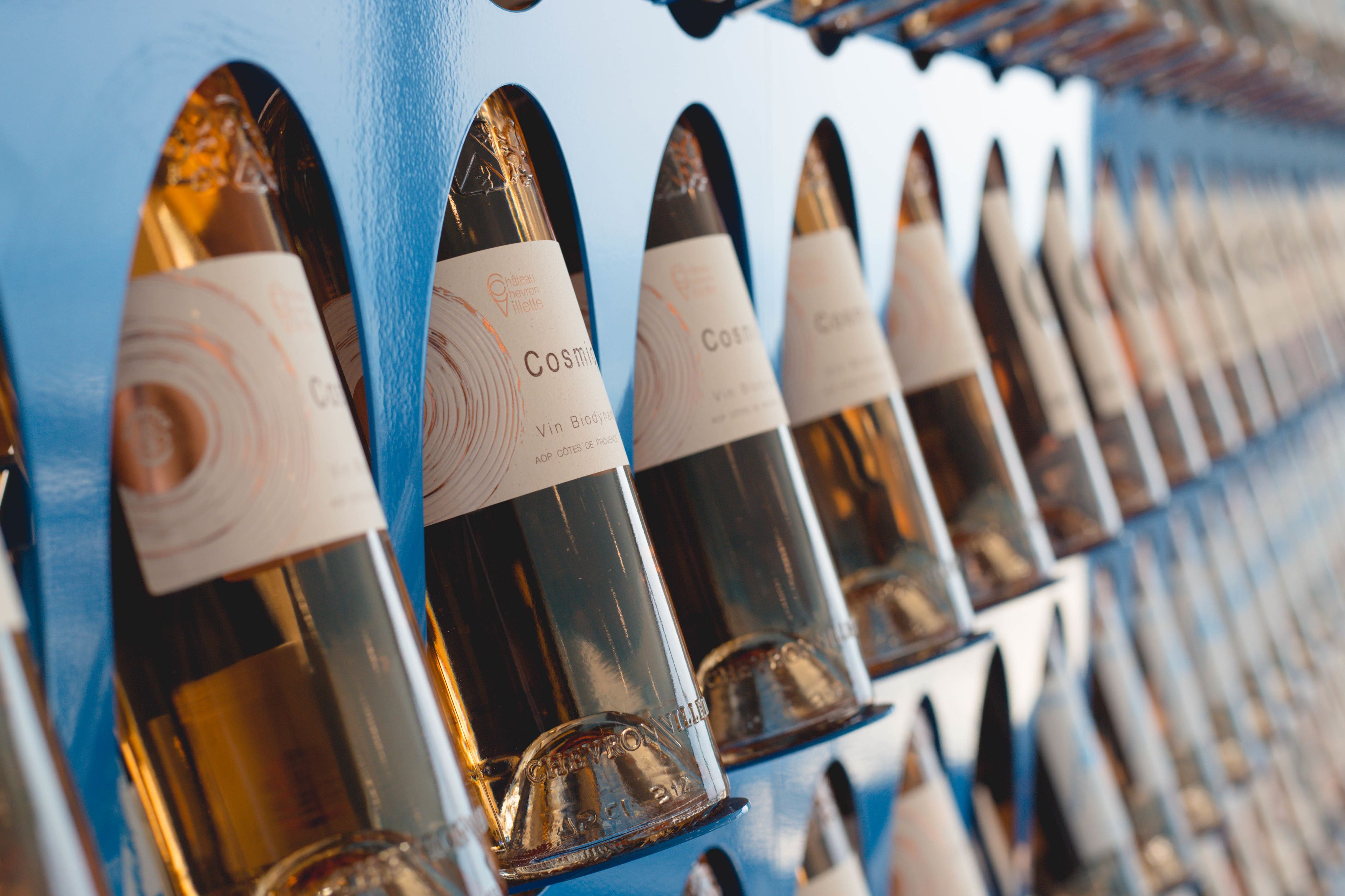 A row of wine bottles with labels, arranged in a neat, orderly fashion.
