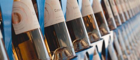 A row of wine bottles with labels, arranged in a neat, orderly fashion.