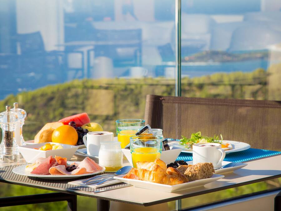 Une table de petit-déjeuner avec divers aliments et boissons, offrant une vue panoramique.
