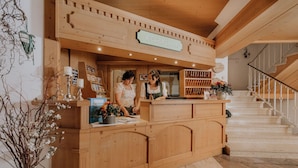 Un mostrador de recepción de madera con un cartel que dice "RECEPTION" y una escalera al fondo.