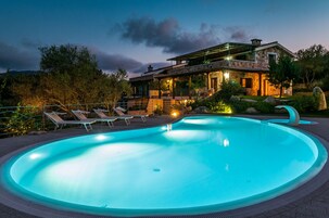 Una piscina al aire libre de temporada, sombrillas