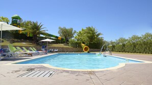 A swimming pool with lounge chairs and a slide. - L'Oasi di Pierino (Ponzano di Fermo)