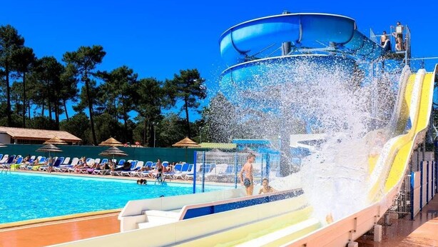 Ein Wasserpark mit großem Pool, Wasserrutschen und Liegestühlen.