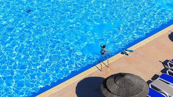 Piscine couverte, piscine extérieure, parasols de plage, chaises longues