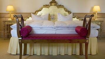 Una cama con cabecera de madera, ropa de cama blanca y una colcha de diseño rojo y blanco.